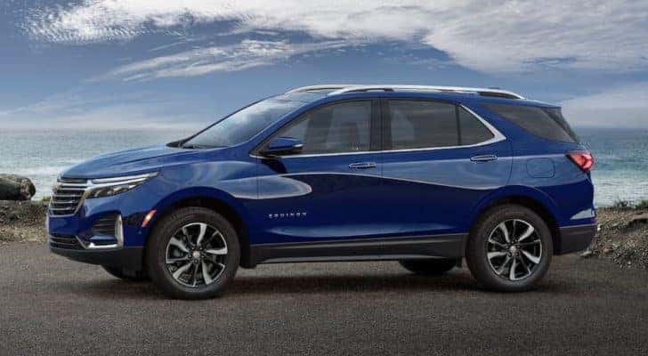 A blue 2023 Chevy Equinox is shown from the side after leaving a Chevy SUV dealer.