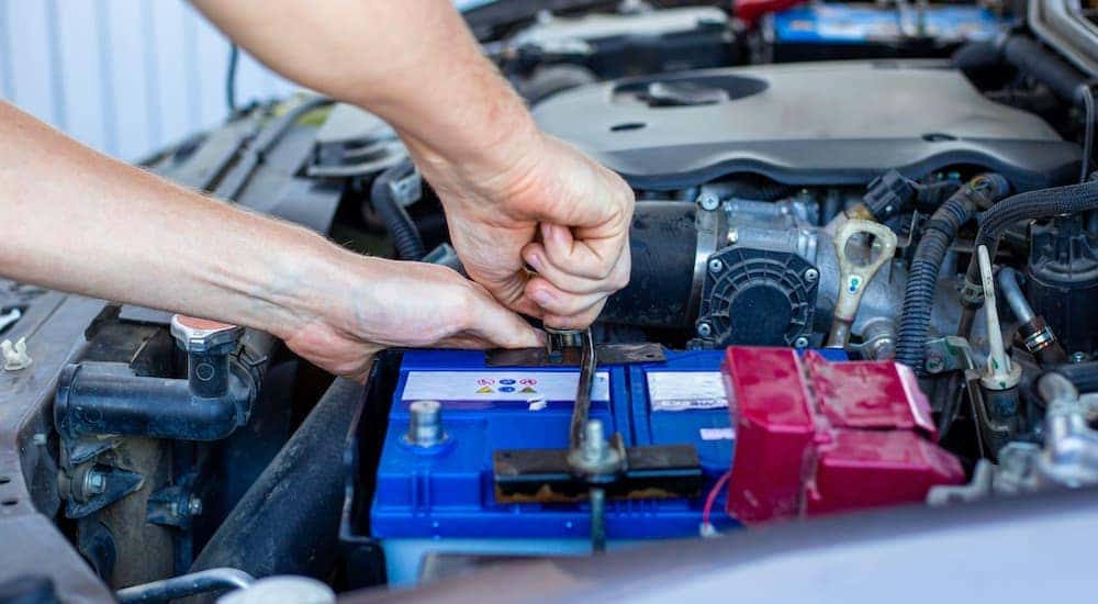 A close up shows a person changing a battery.