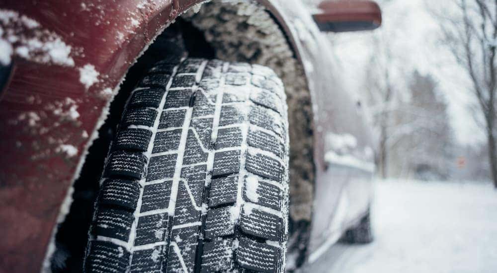 A snowy tire is shown in close up.