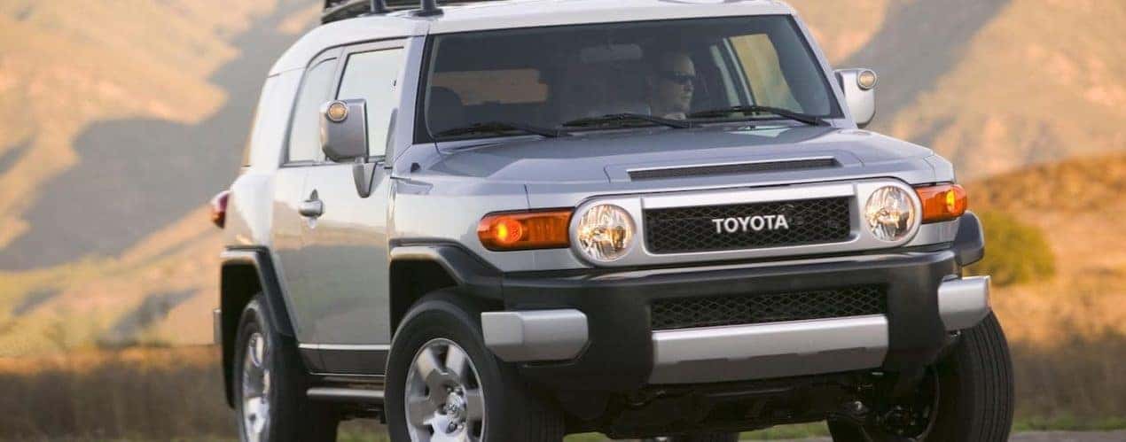 A silver 2008 Toyota FJ Cruiser is shown driving in the mountains.