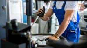 A mechanic is shown taking a tire off of a rim at a Cincinnati, OH, tire center.