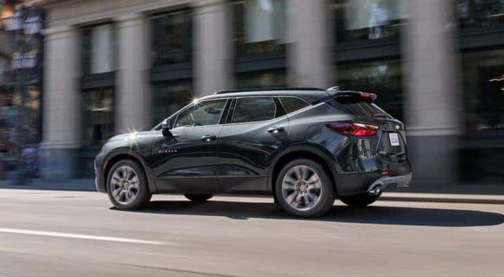 A black 2021 Chevy Blazer is shown from the side driving through a city.