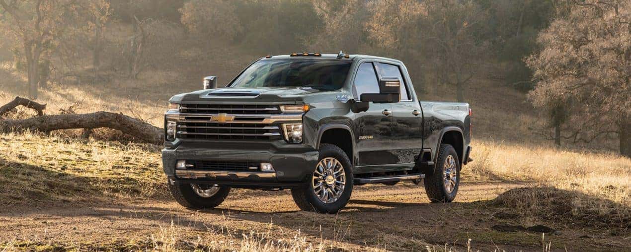 A black 2023 Chevy Silverado 2500 HD High Country is shown parked in an open field.