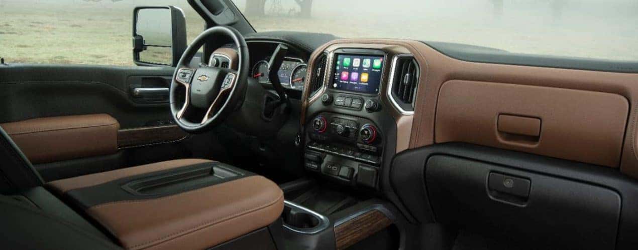 The black and brown 2023 Chevy Silverado 2500 HD shows the steering wheel and center console.