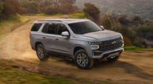 A grey 2023 Chevy Tahoe Z71 is shown on a dirt trail after leaving a Chevy Tahoe dealer.