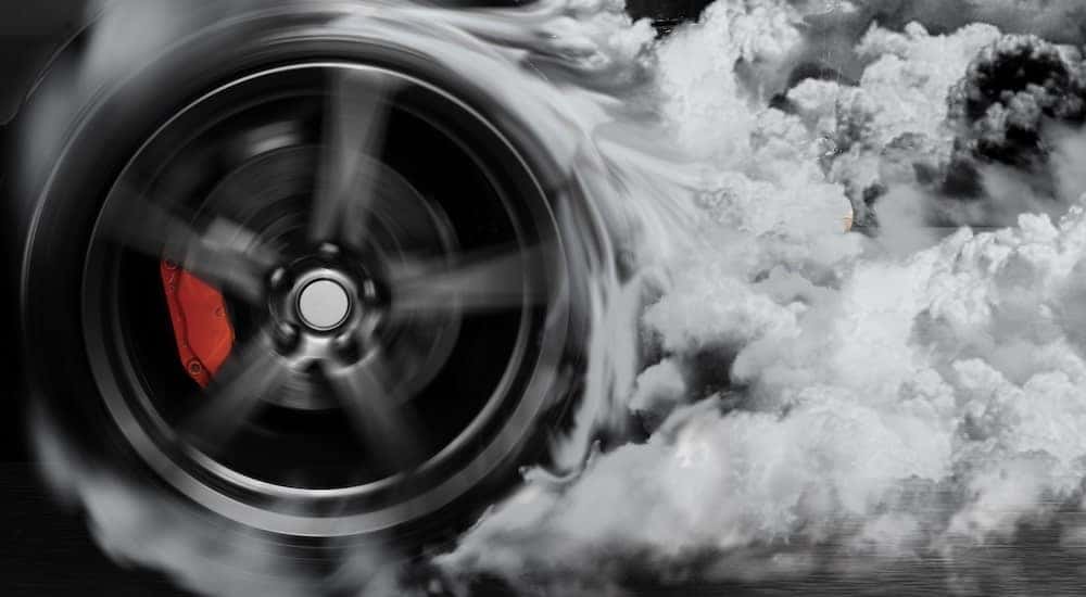 A performance tire is shown doing a burn out.