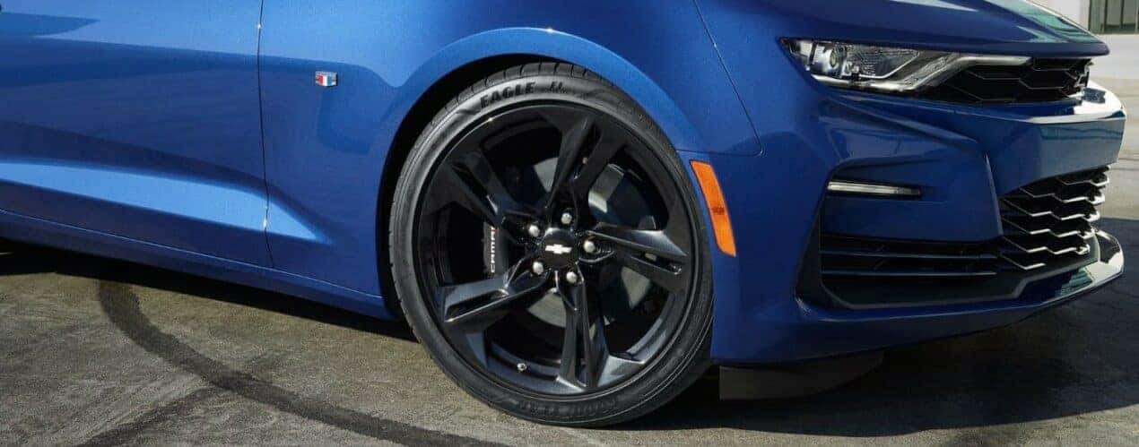A close up shows the black wheel on a blue 2023 Chevy Camaro SS.