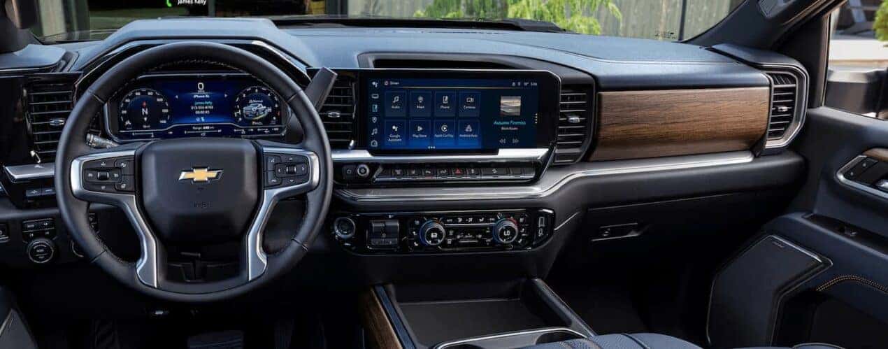 The black and brown interior of a 2024 Chevy Silverado 3500 HD shows the steering wheel and center console.
