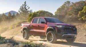 A red 2023 Chevy Colorado Trail Boss is shown from the front at an angle after leaving a dealer that has Chevy trucks for sale in Cincinnati.