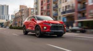 One of the most popular Chevy SUVs for sale near Hamilton, a red 2019 Chevy Blazer RS, is shown on a city street
