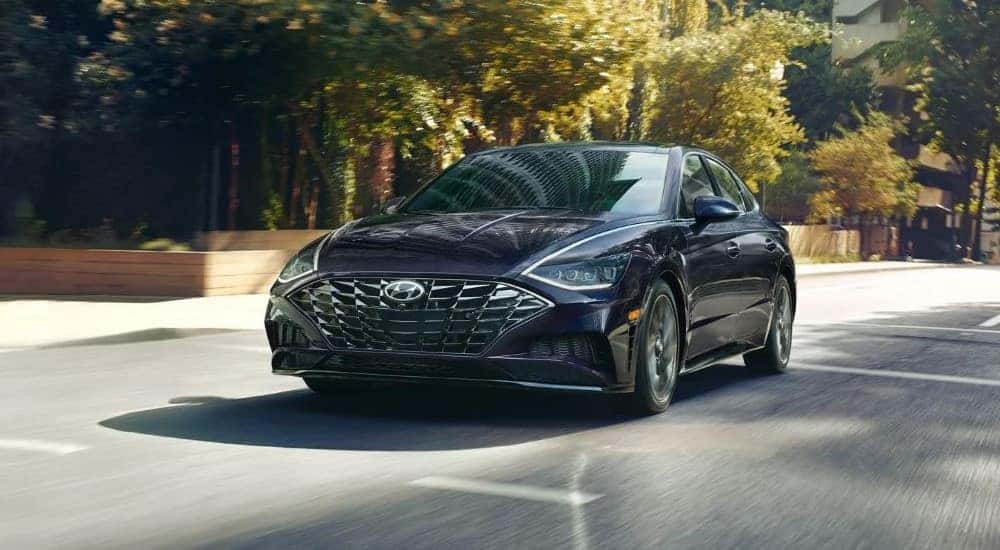 A black 2022 Hyundai Sonata Limited is shown driving on a city street.