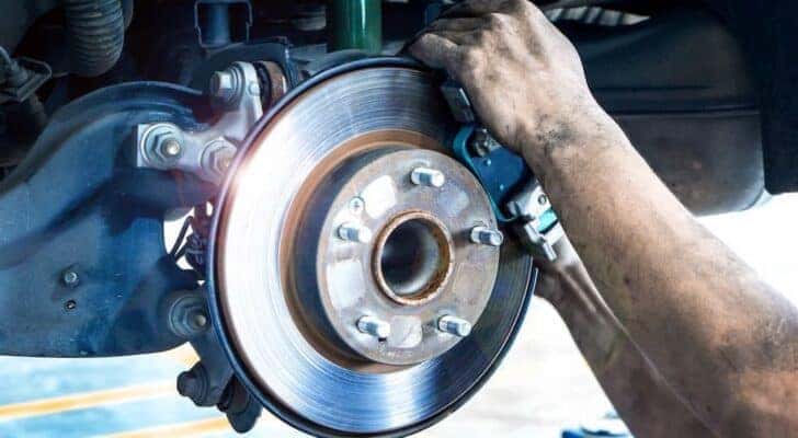 A person is shown performing a brake service.