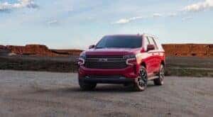 Red 2021 Chevy Tahoe parked on gravel.