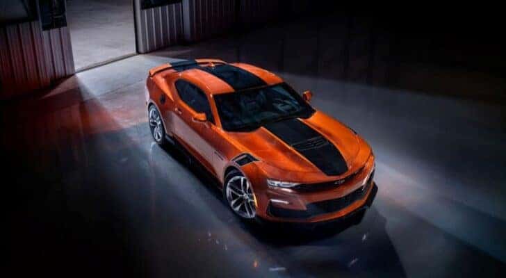 An orange 2023 Chevy Camaro SS is shown parked in a hangar after viewing cheap used cars near Middletown.