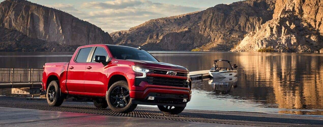A red 2024 Chevy Silverado 1500 LTZ Z71 is shown parked near a body of water.
