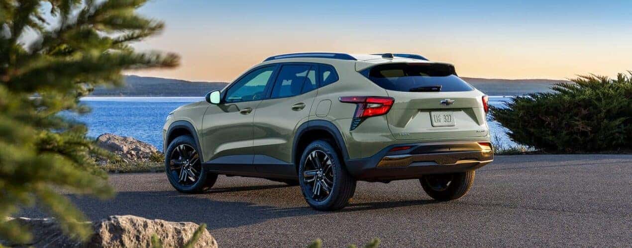 A green 2024 Chevy Trax Activ is shown from the rear parked near a body of water.