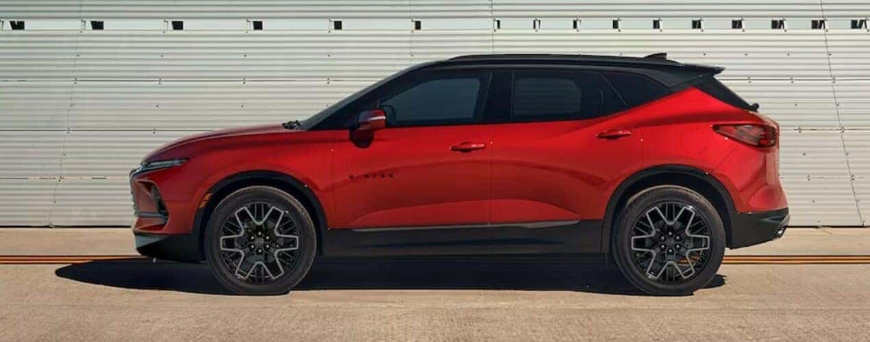 A red 2024 Chevy Blazer is shown parked near bleachers after a 2024 Chevy Blazer vs 2024 Ford Edge comparison.