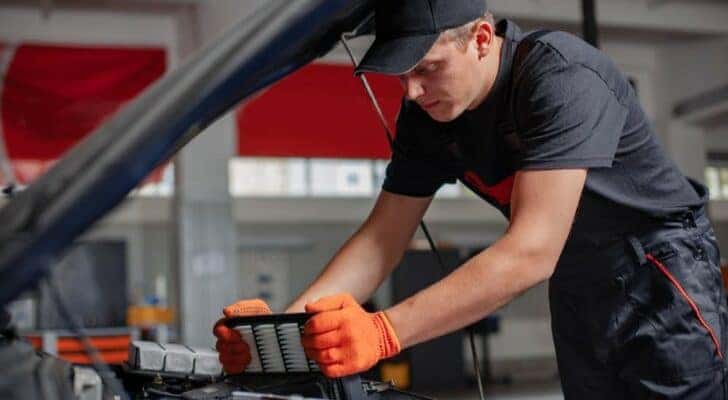 A mechanic is shown performing a car air filter replacement in Cincinnati.
