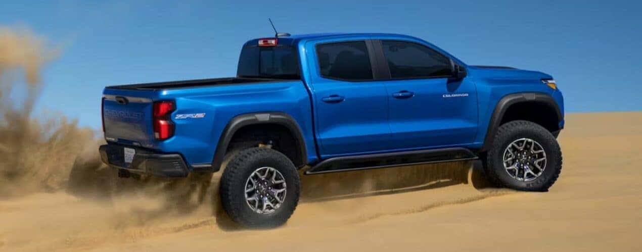 A blue 2024 Chevy Colorado ZR2 is shown driving on sand after a 2024 Chevy Colorado vs 2024 Ford Ranger comparison.