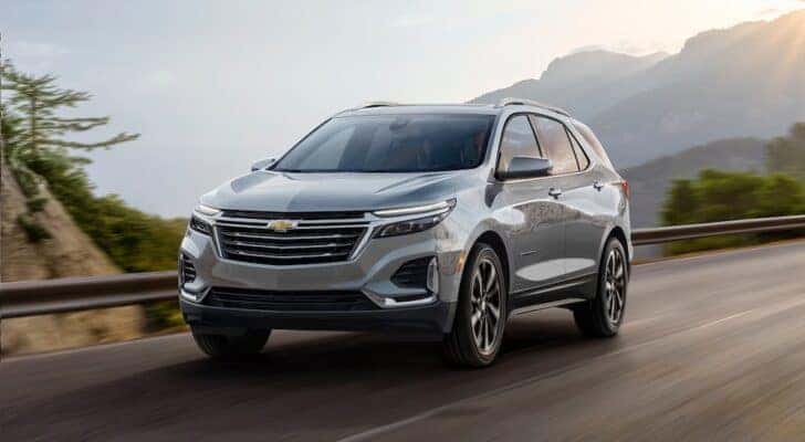 A silver 2024 Chevy Equinox is shown driving from a Chevy dealer near Montgomery.