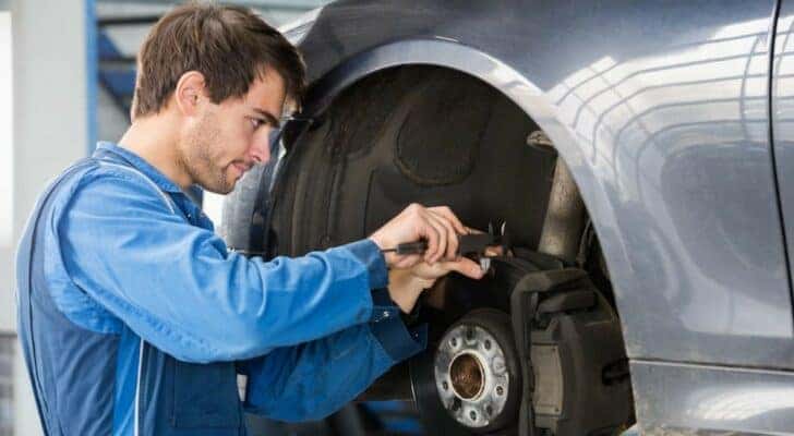 A mechanic is shown working on a vehicle.