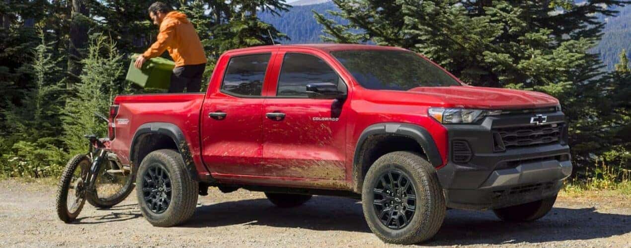 A red 2024 Chevy Colorado Trail Boss is shown parked off-road.