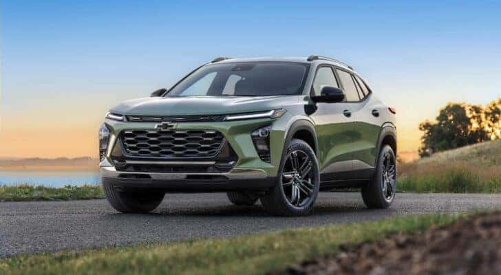 A green 2024 Chevy Trax ACTIV driving down a road.