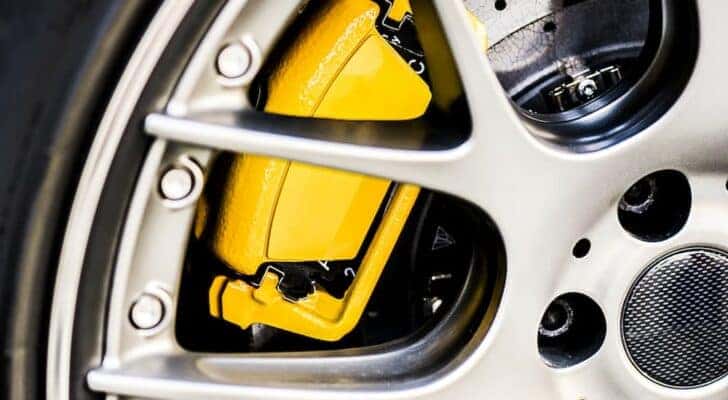 A yellow brake caliper is shown in close-up after receiving brake service near Loveland.