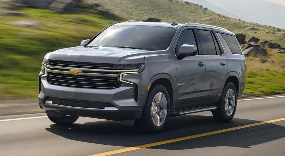 A gray 2021 Chevy Tahoe is shown driving on a highway.