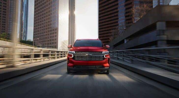A front view of a red 2022 Chevy Tahoe driving on a highway ramp.