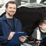 A mechanic is shown holding a clipboard at a GMC service center.