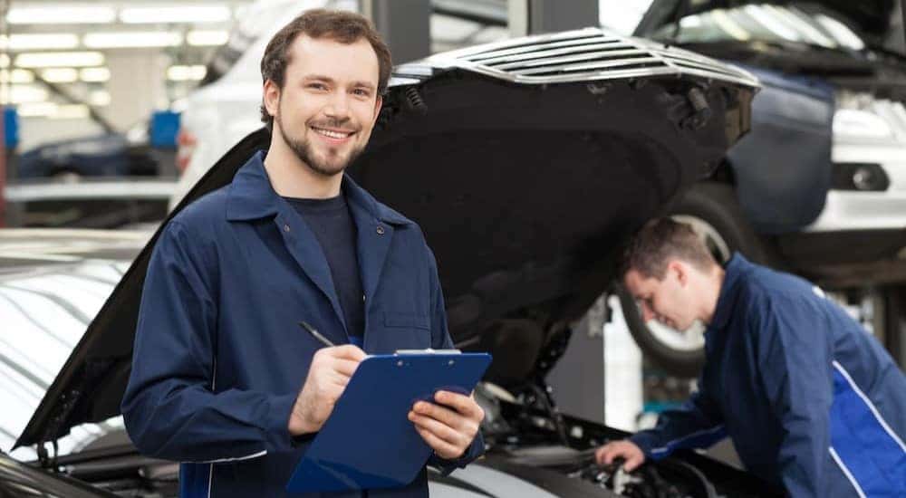 A mechanic is shown holding a clipboard at a GMC service center.