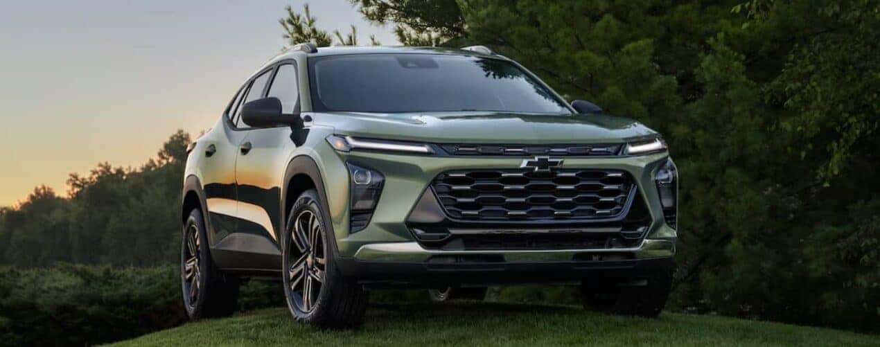 A green 2025 Chevy Trax ACTIV is shown parked off-road.