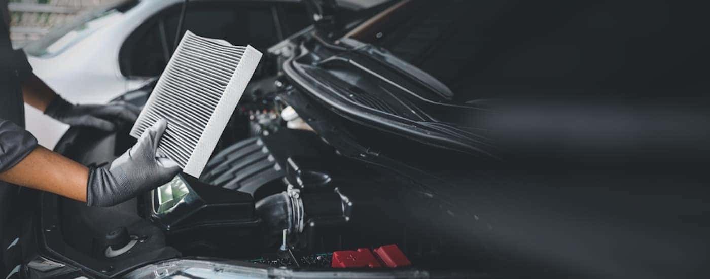 A mechanic holding a car air filter at a Honda service center.