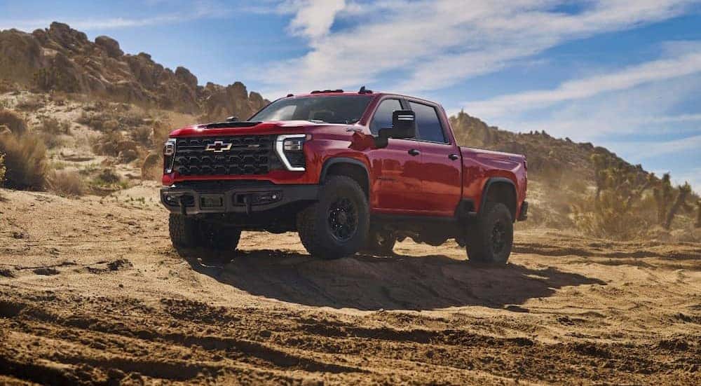 A red 2025 Chevy Silverado 2500 ZR2 Bison Edition is shown parked off-road.