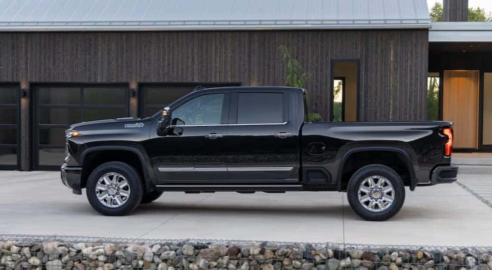 A black 2025 Chevy Silverado 2500 HD High Country is shown parked on a driveway.