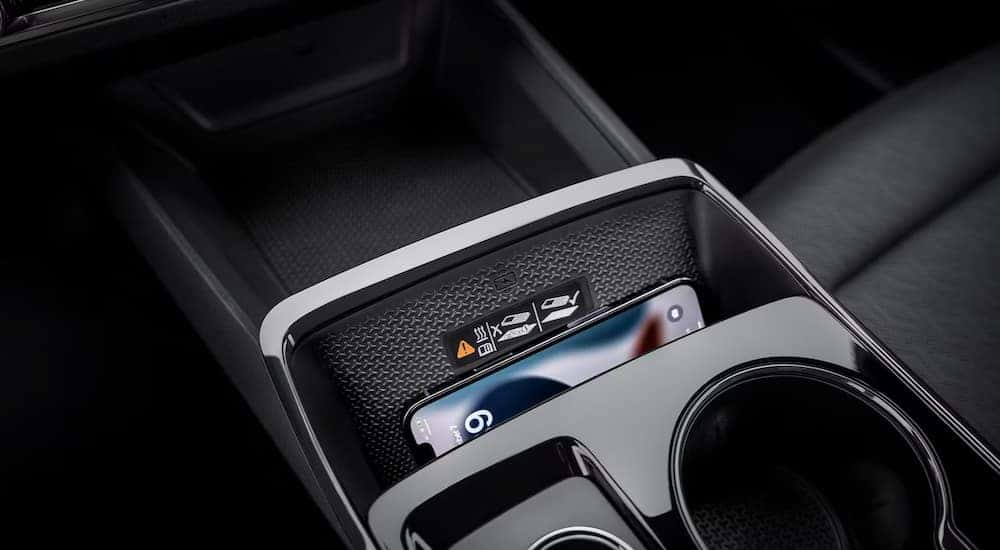 Close-up of a smartphone on the wireless charging pad in a 2025 Chevy Equinox for sale.