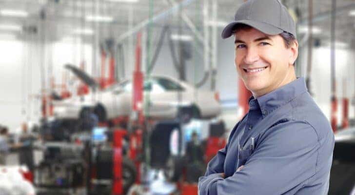 A technician is shown smiling at a Buick service center in Cincinnati.