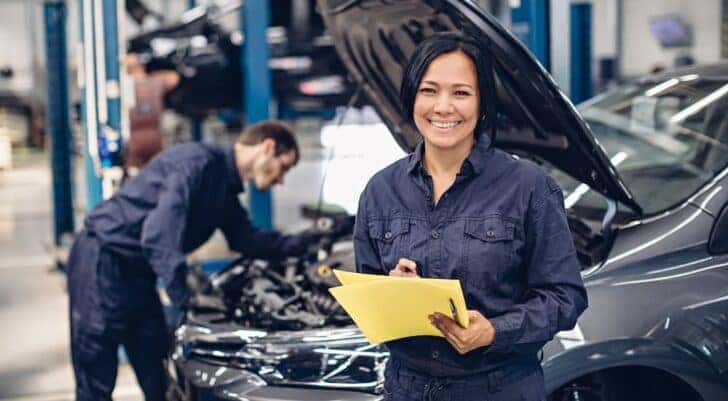 A technician is shown smiling at a Toyota service center in Cincinnati.
