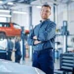 A technician is shown smiling at a Toyota service center in Cincinnati.