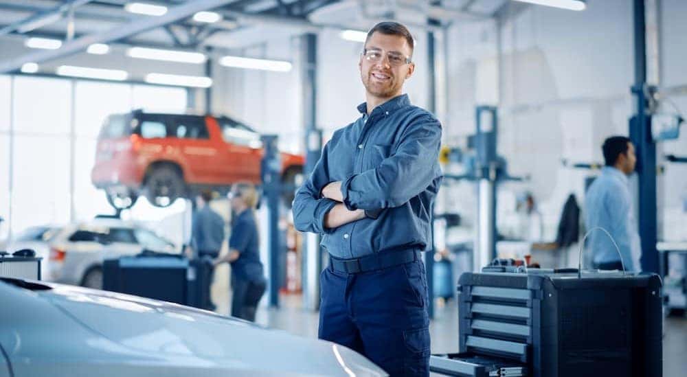 A technician is shown smiling at a Toyota service center in Cincinnati.