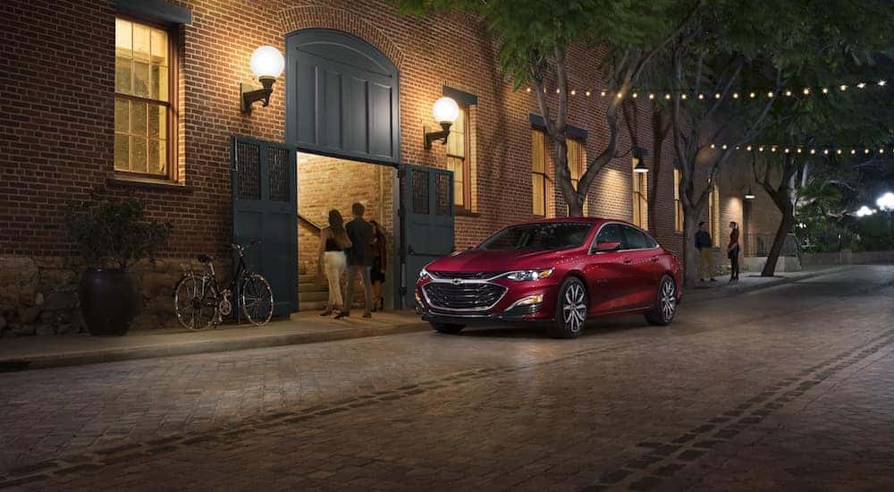A red 2021 Chevy Malibu RS is shown from the front at an angle after leaving a dealer that has a used Chevy Malibu for sale.