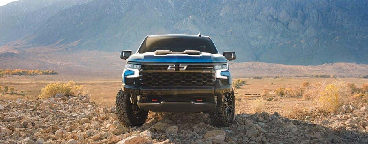 A blue 2025 Chevy Silverado 1500 ZR2 is shown parked off-road.