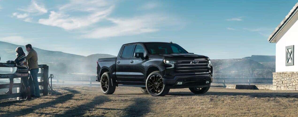 A black 2025 Chevy Silverado 1500 High Country Midnight Edition is shown parked on a ranch.