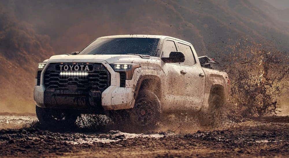 A white 2025 Toyota Tundra TRD Pro is shown driving on mud.
