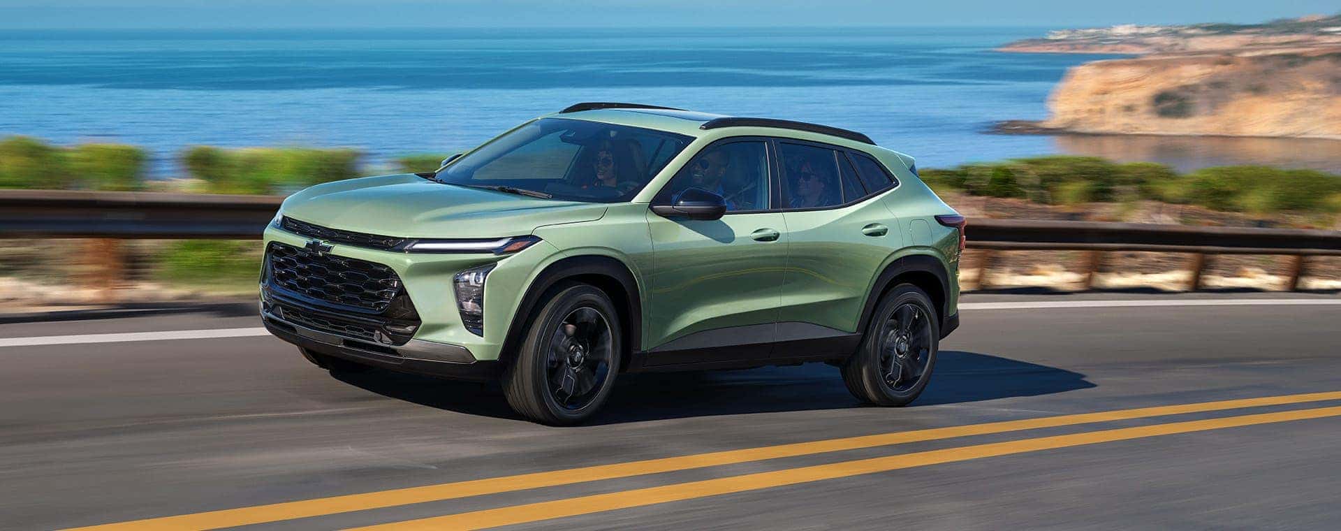 A green 2025 Chevy Trax driving on an open road.