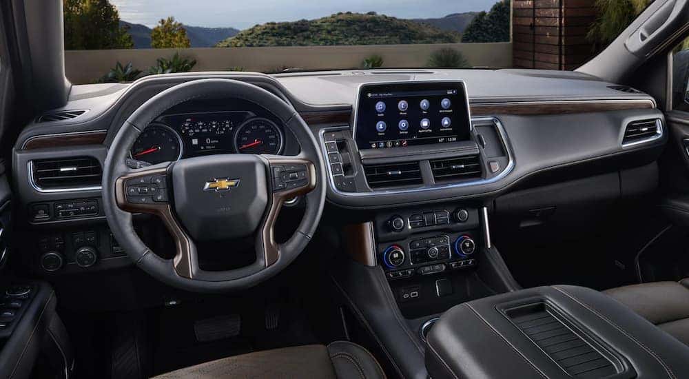 The black interior of a 2021 used Chevy Suburban for sale is shown from the drivers seat.