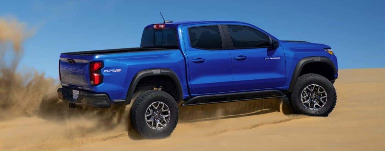 A blue 2025 Chevy Colorado ZR2 is shown off-roading.