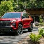 A red 2025 Chevy Traverse RS is shown from the front at an angle.