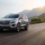 A silver 2023 Chevy Equinox Premier driving to view used cars for sale in Cincinnati.